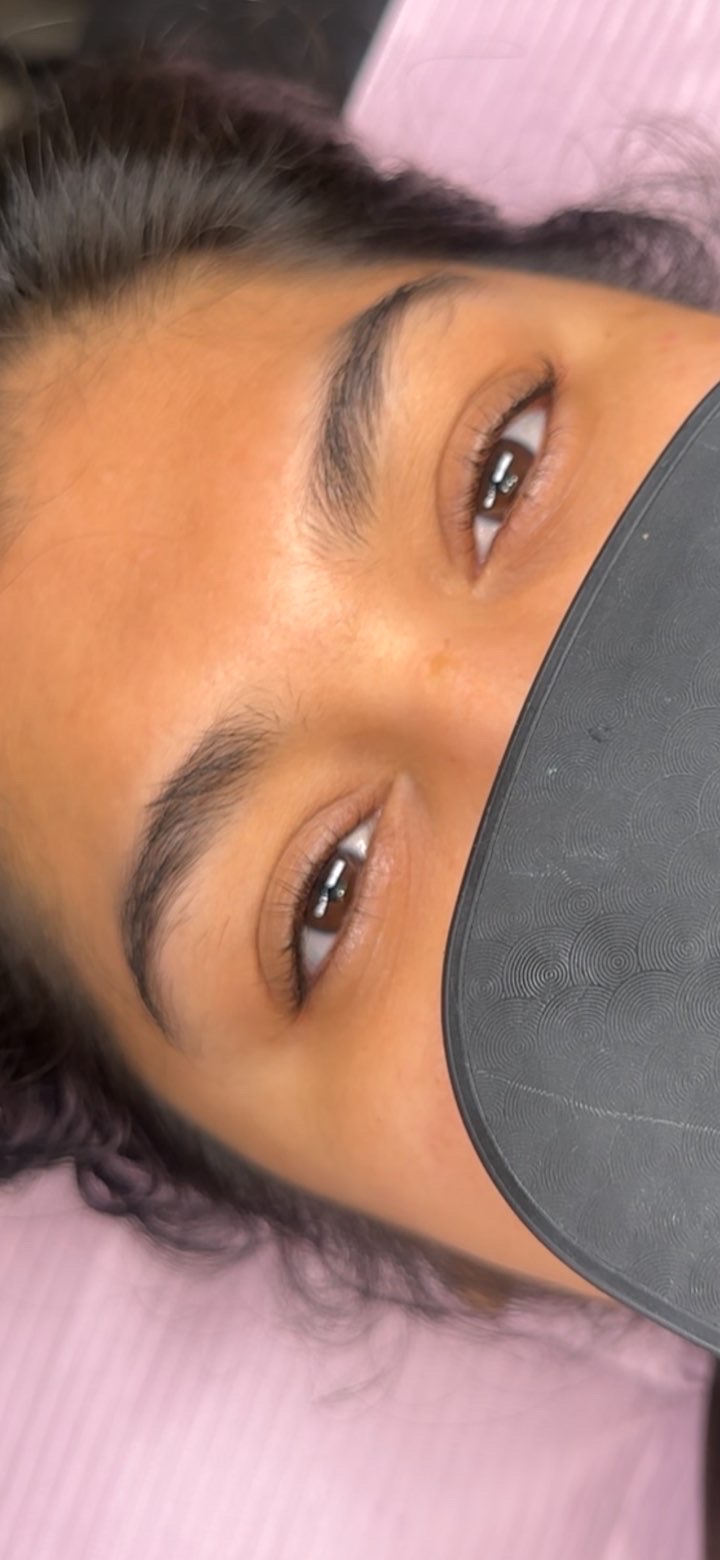Before: close-up of the client's open eyes with straight, light natural lashes.
